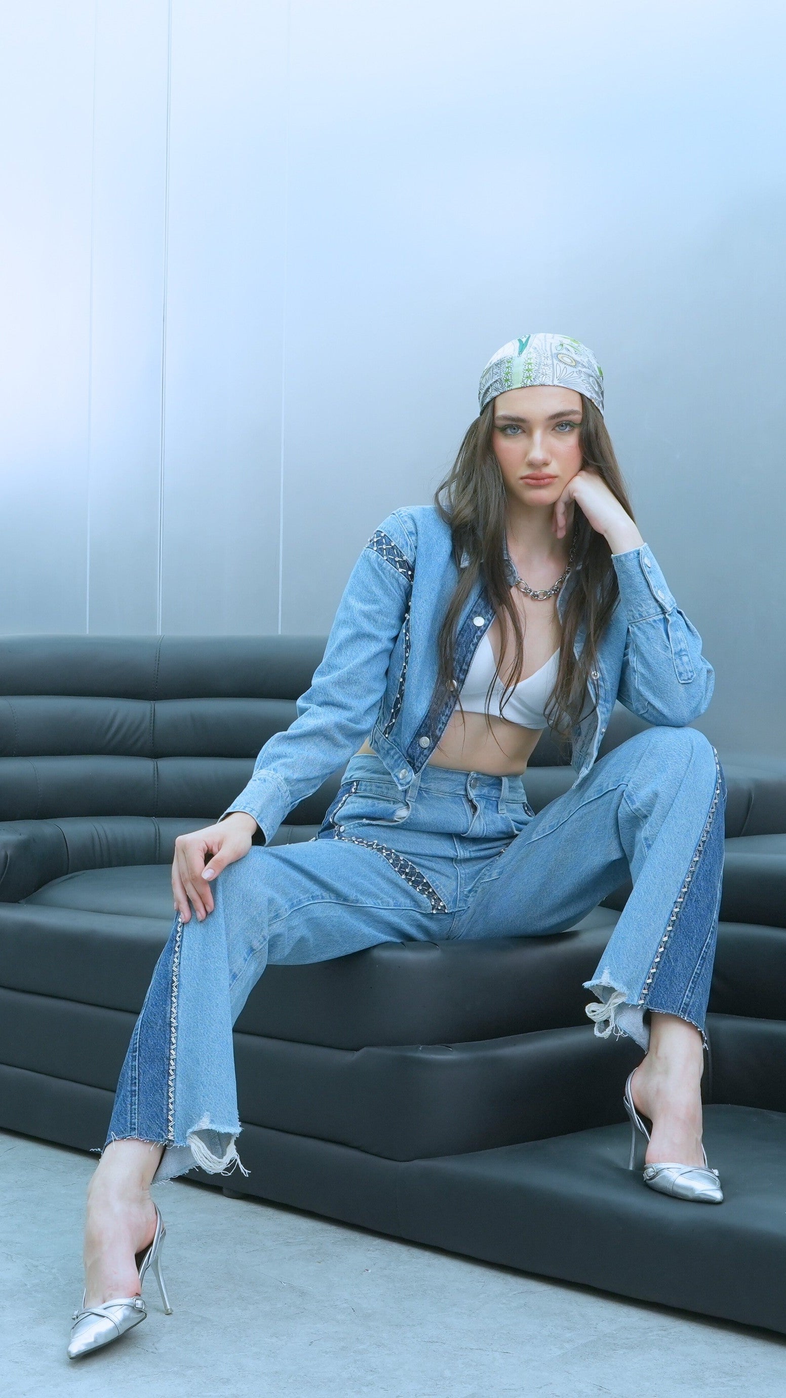 Woman sitting on a gray inflatable couch against a light blue wall.